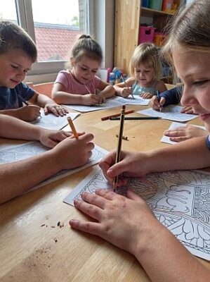 Kinder malen kostenlose Ausmalbilder am Tisch und fördern ihre Kreativität
